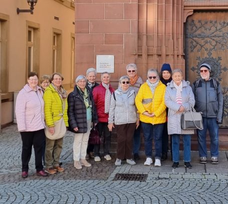 Gruppe von Personen, die vor einem historischen Gebäude posieren.